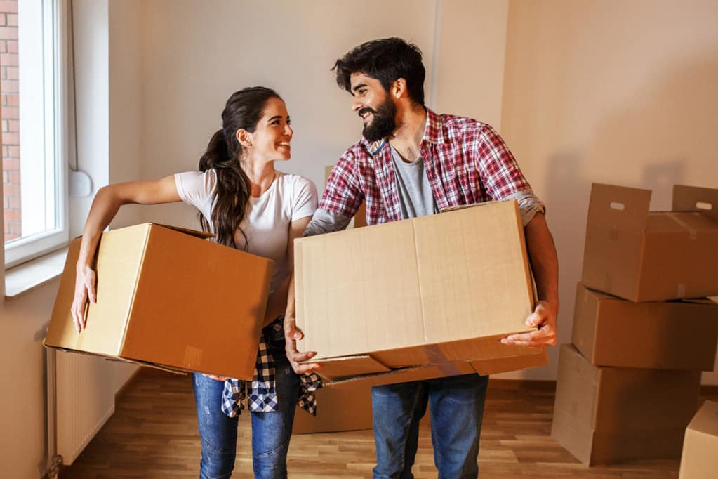 Happy couple carrying box